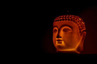 Close-up of illuminated lamp against black background