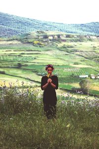 Portrait of woman photographing on field