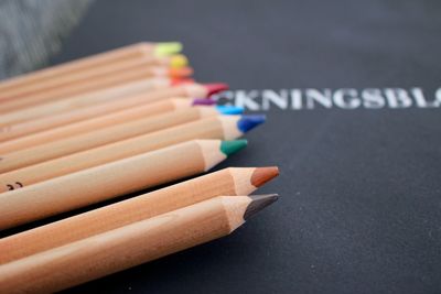 High angle view of wooden colored pencils on blackboard