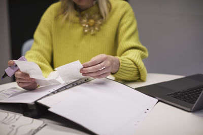 Businesswoman checking receipts in office