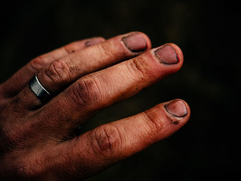 Cropped image of dirty hand on black background