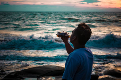 Rear view of man photographing sea