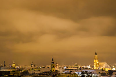 View of illuminated buildings against cloudy sky
