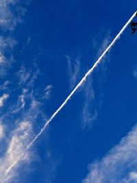 Low angle view of vapor trail in blue sky