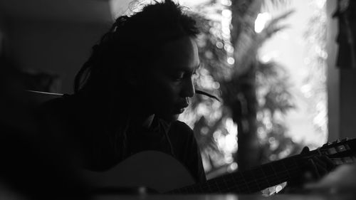 Portrait of young woman playing guitar