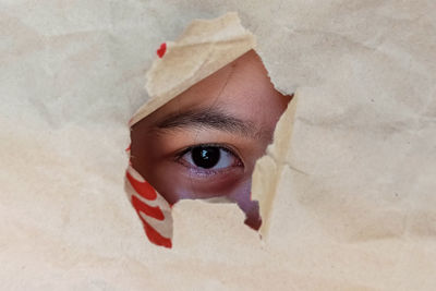 Girl peeking through broken paper