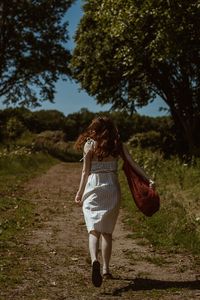 Woman with umbrella walking on field