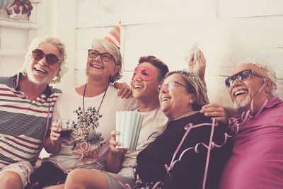 Happy friends sitting on sofa at home