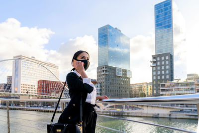 Full length of woman standing against buildings in city