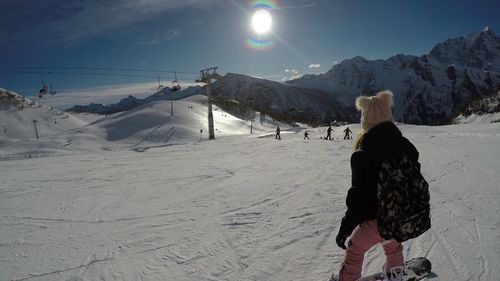 Woman on snow covered mountain against sky