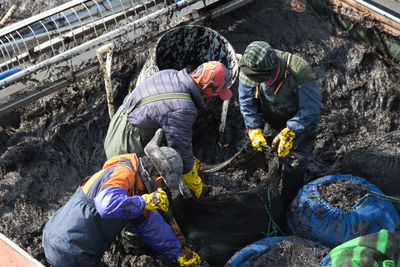 High angle view of workers working in mud