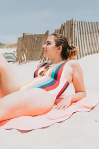 Young woman sitting on sand at beach