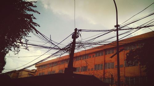 Low angle view of electricity pylon against sky