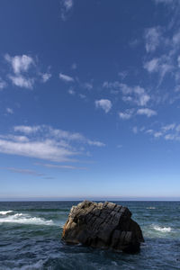 Rocks on sea shore against sky