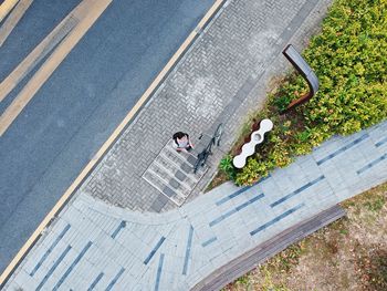 Directly above shot of man with bicycle standing at sidewalk