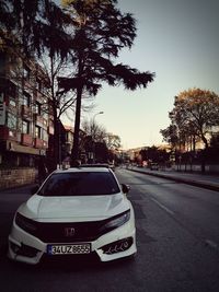 Car on street in city against sky