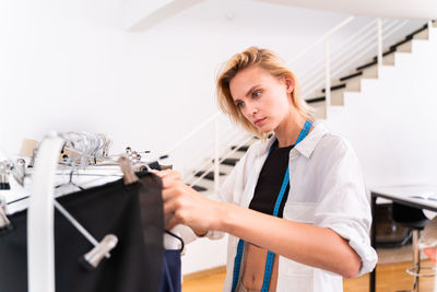 Young fashion designer working at boutique