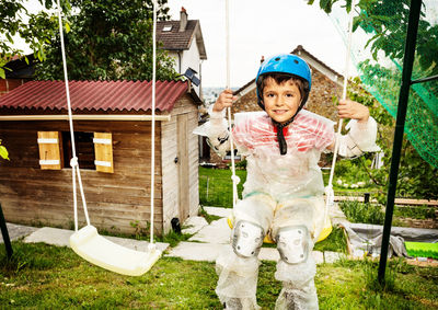 Portrait of boy sitting on swing