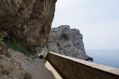 Rock formations by sea against sky