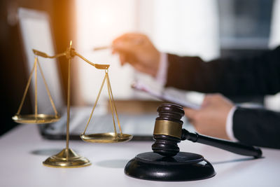 Close-up of hand holding wine glasses on table