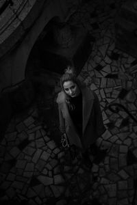 High angle portrait of woman standing on cobblestone