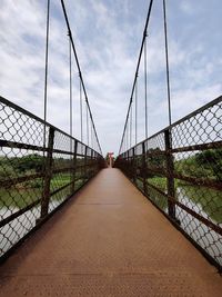 View of hanging iron bridge against sky