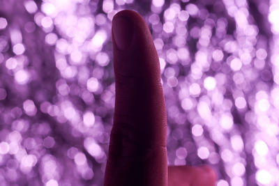 Index finger with purple blurry background