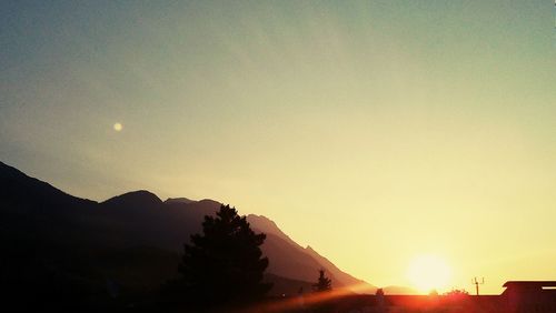 Sun shining through clouds over mountains