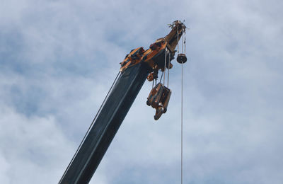 Low angle view of cranes against sky