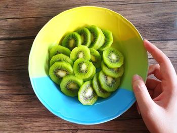 High angle view of hand holding fruits on table