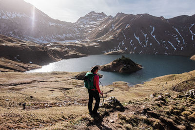 Rear view of woman standing on field against mountain