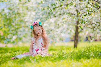 Portrait of cute girl with flowers in field