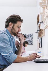 Side view of business people working at desk in office