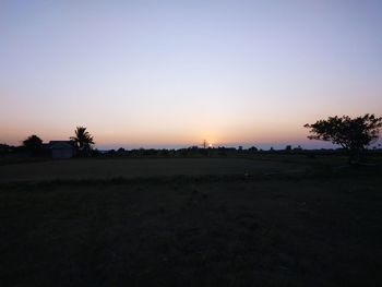 Scenic view of silhouette field against clear sky during sunset