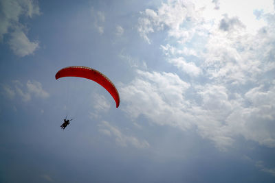 Low angle view of person paragliding against sky