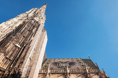 Low angle view of church building against blue sky in vienna 