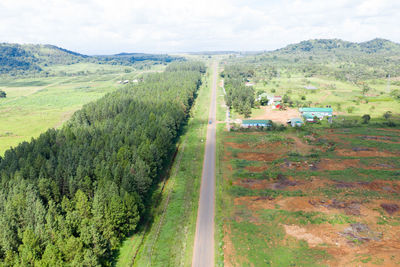 High angle view of road amidst trees on field against sky