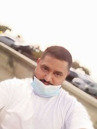 Portrait of young man sitting on car