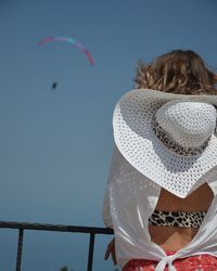 Rear view of woman flying against clear sky