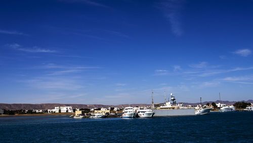 Sailboats in sea against blue sky