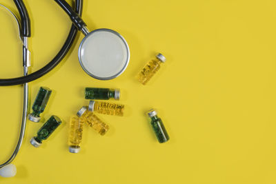 High angle view of coins on yellow table