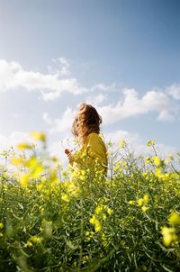 Low angle view of woman standing on field against sky