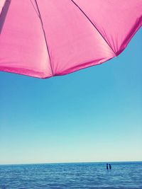Pink parasol against sea