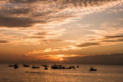 Silhouette sailboats in sea against sky during sunset