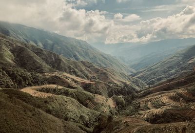 Scenic view of valley and mountains against sky