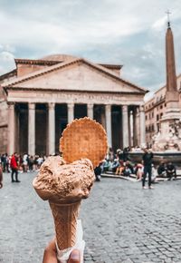 People holding ice cream in city