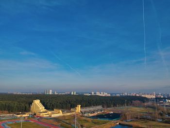 Aerial view of cityscape against blue sky