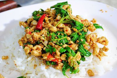 Close-up of basil rice with squid and chicken in plate