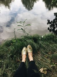 Low section of person standing by lake