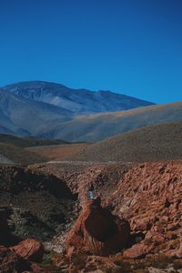 Man standing on rock against sky